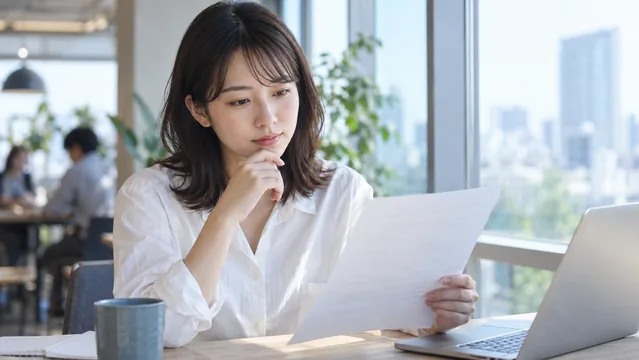 募集要項を読みながら考える人物（生成イメージ）