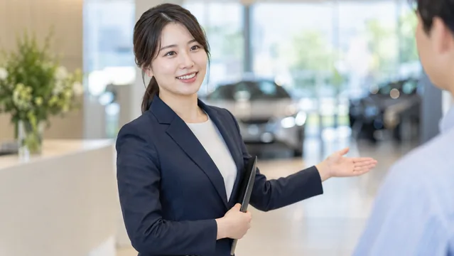ショールームの受付で案内する人物（生成イメージ）